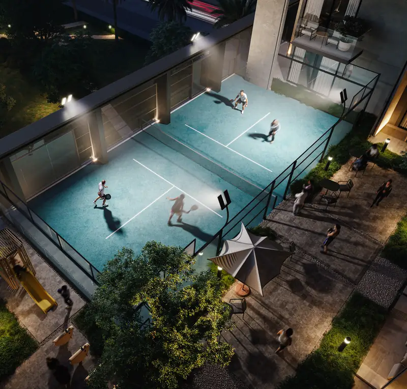 Floodlit social padel court on the Level 1 podium garden at Kore by Imtiaz, seen from above at night